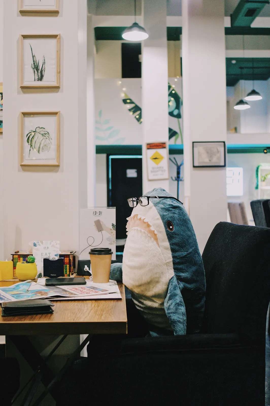 Image d’un Blaja portant des lunettes, il est mega posay devant un bureau avec son mug de café | Symphonie of Code, Agence informatique, hébergement, et services numériques en Lozère 